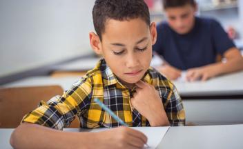Elementary boy in yellow plaid shirt taking a test