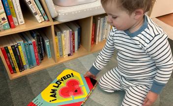 Toddler looking at colorful board book