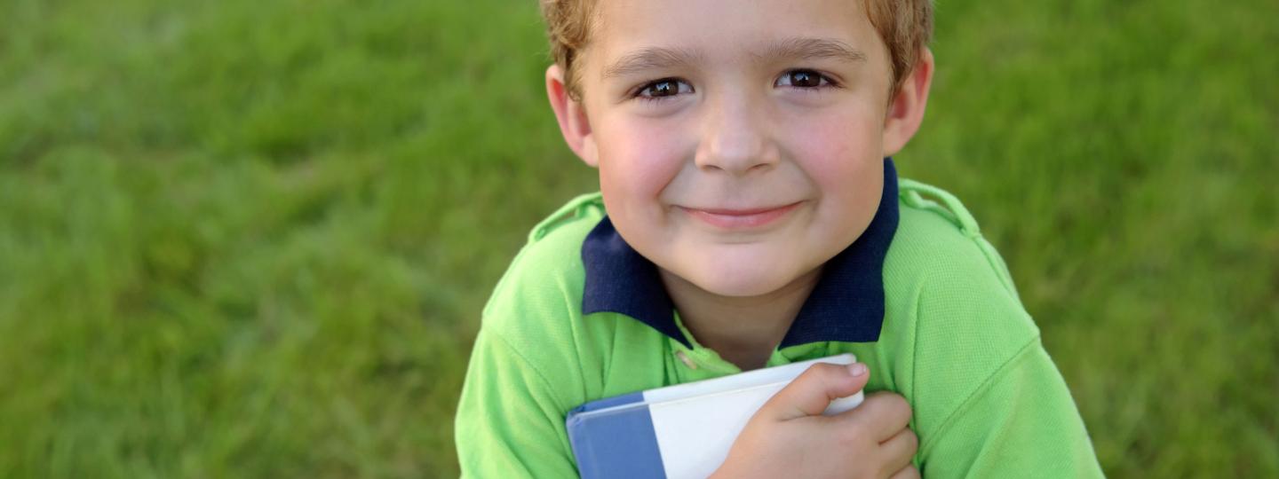 closeup of young boy holding a book